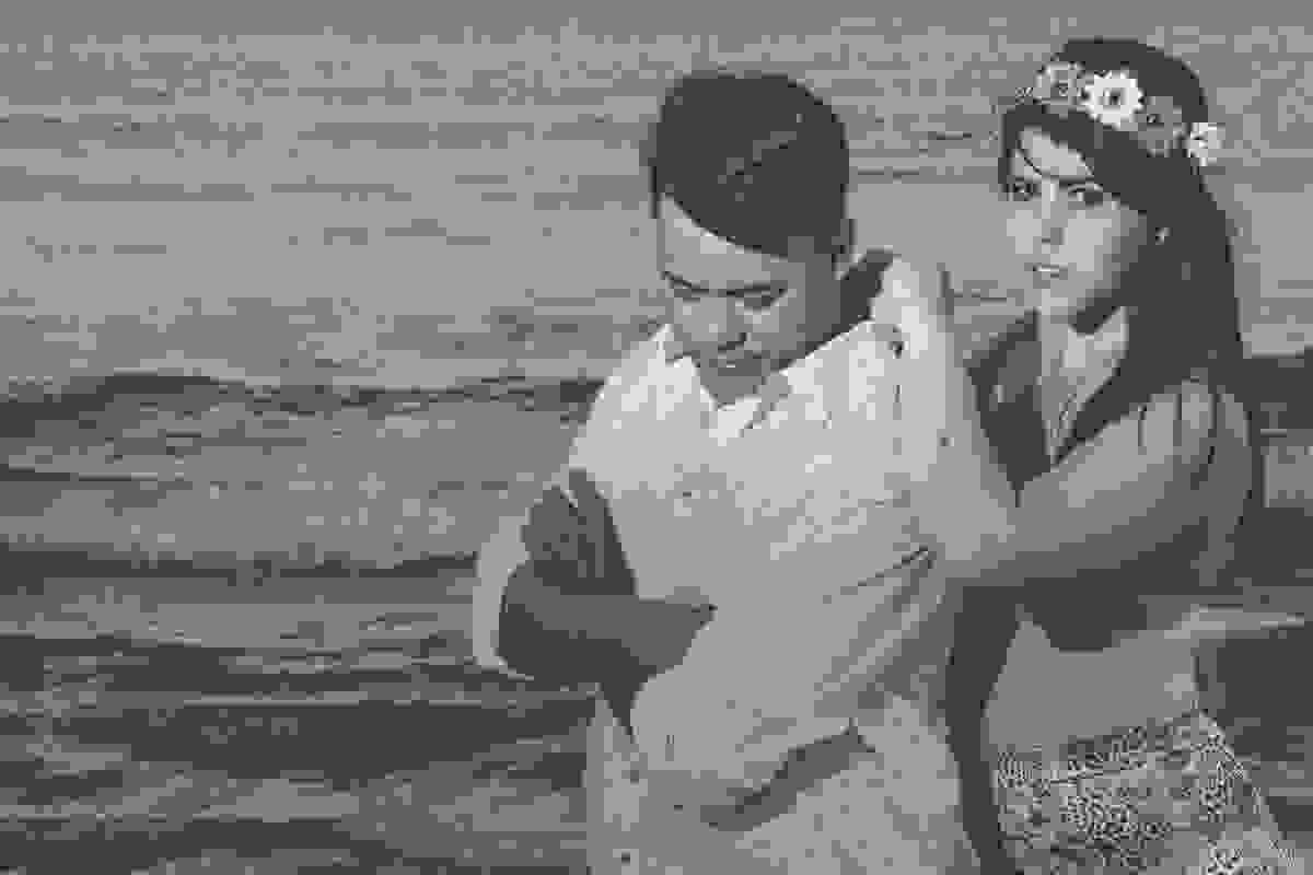 noiva apoiada nos ombros do noivo que esta de braços cruzados em ensaio pré casamento na praia de geribar em búzios rio de janeiro