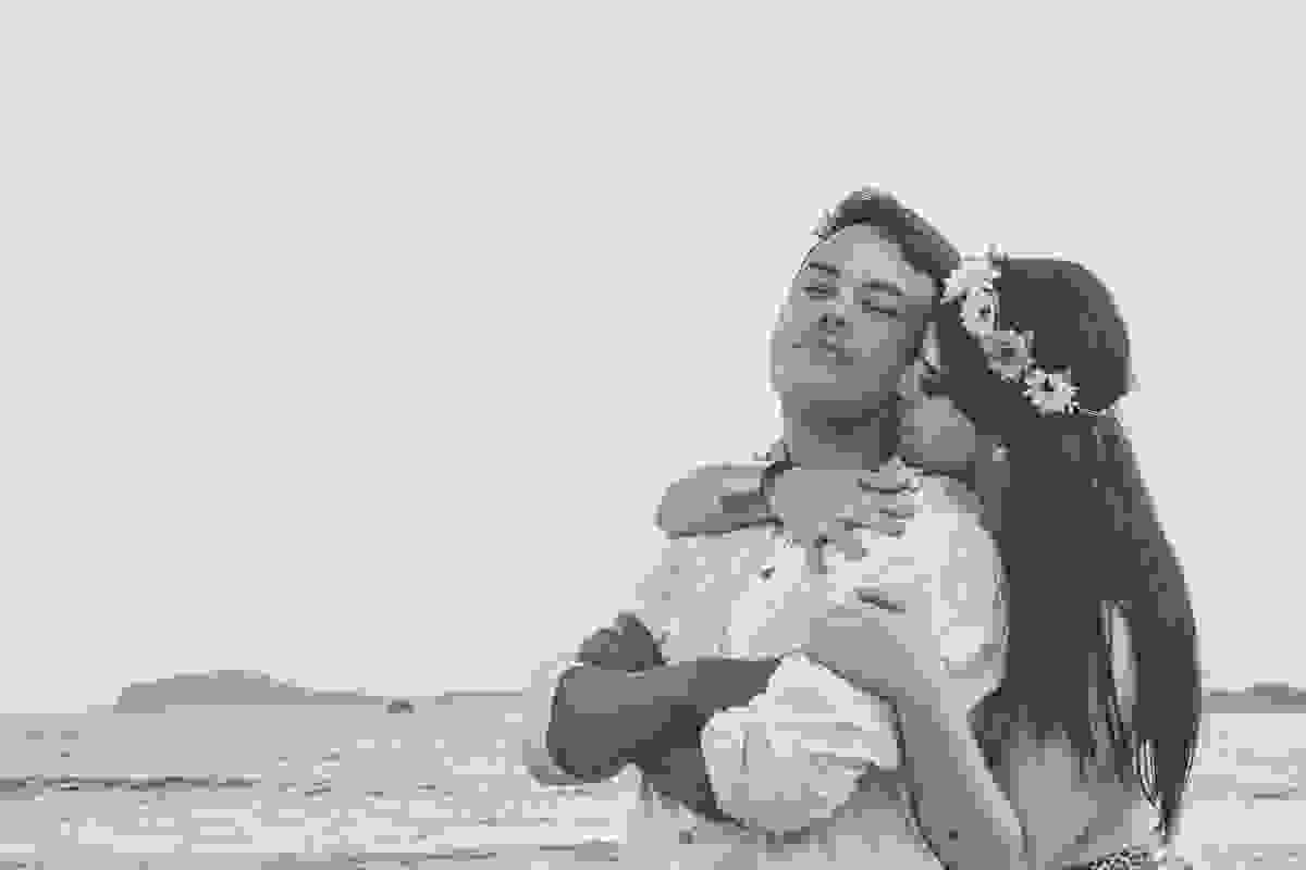 noiva abraça o noivo por de traz e dá um cheiro em seu cangote em fotorgafia de pré casamento em búzios rio de janeiro