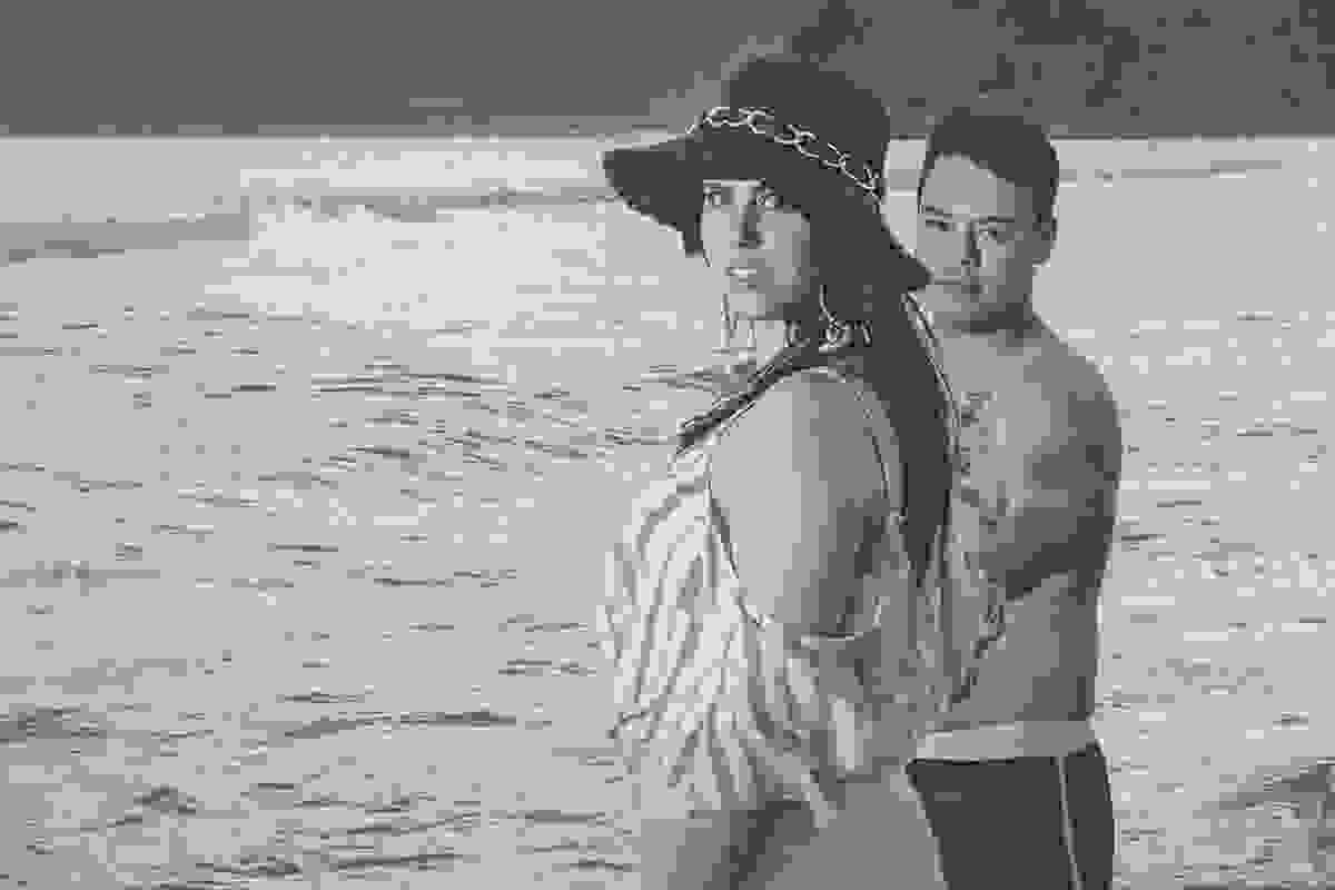 fotorgafia de casamento pré wedding em búzios rio de janeiro mostra o casal de lado olhando para camera e ao fundo o mar