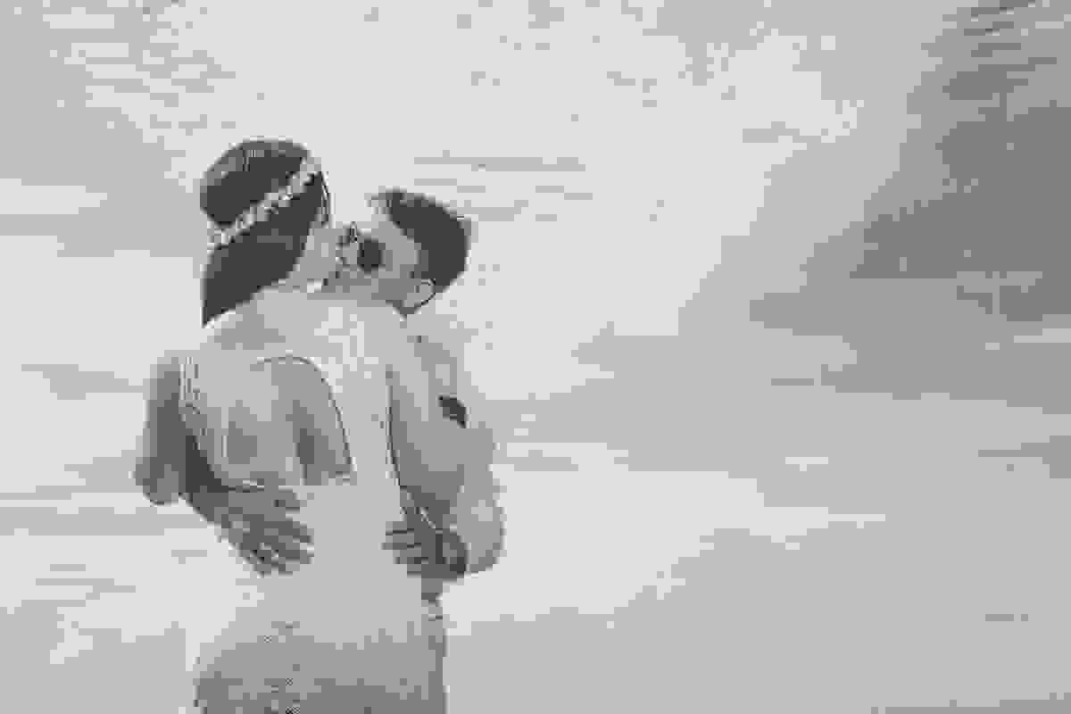 noivo da uma mordinha no queixo da noiva e ao fundo o ceu de búzios no ensaio pré casamento