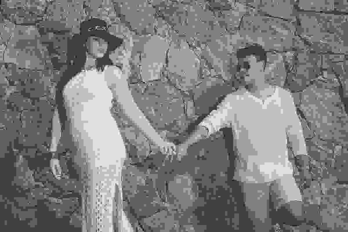casal de mãos dadas de frente para um muro no alto de joão fernandes em Armação dos Búzios