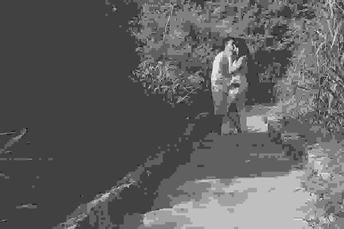 fotografia mostra casal se beijando ao fundo na escadaria de acesso a praia de joão fernandes em búzios rio de janeiro