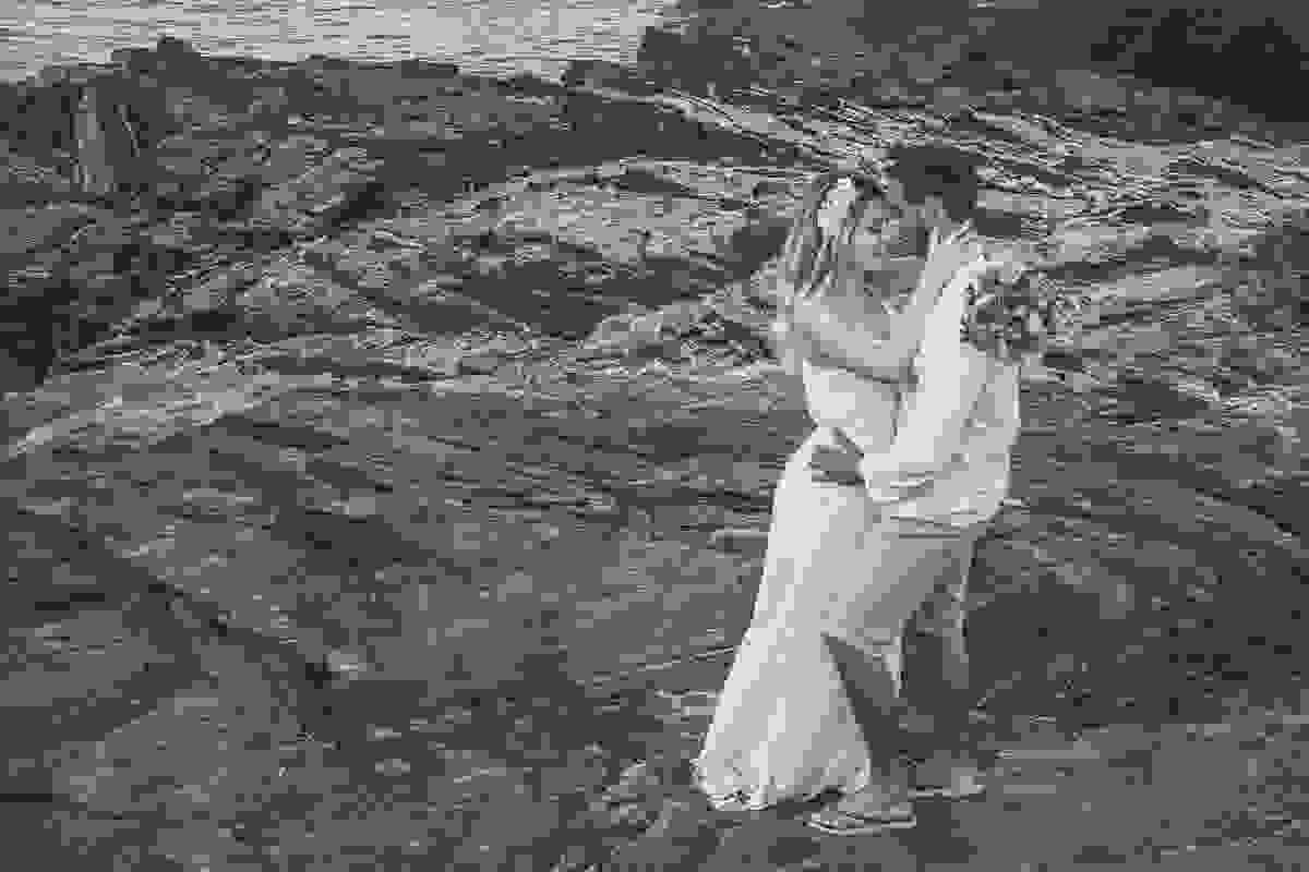 sobre as pedras que compoe o lindo cenário do forte são matheus em cabo frio rio de janeiro o casal esta de pé ela com os braços em volta do pescoço dele