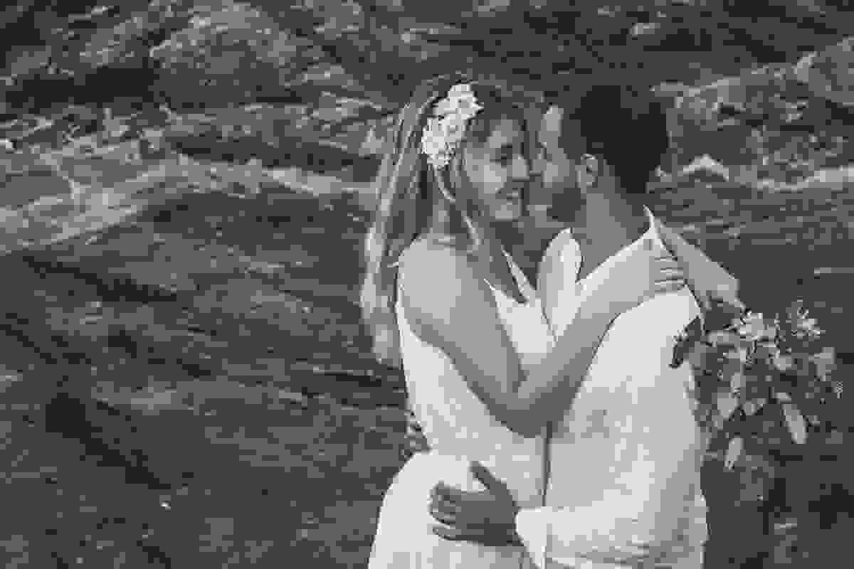 Fotografia de pré casamento casal de frente um para o outro ela sorrindo para ele enguanto é abraçada pela cintura