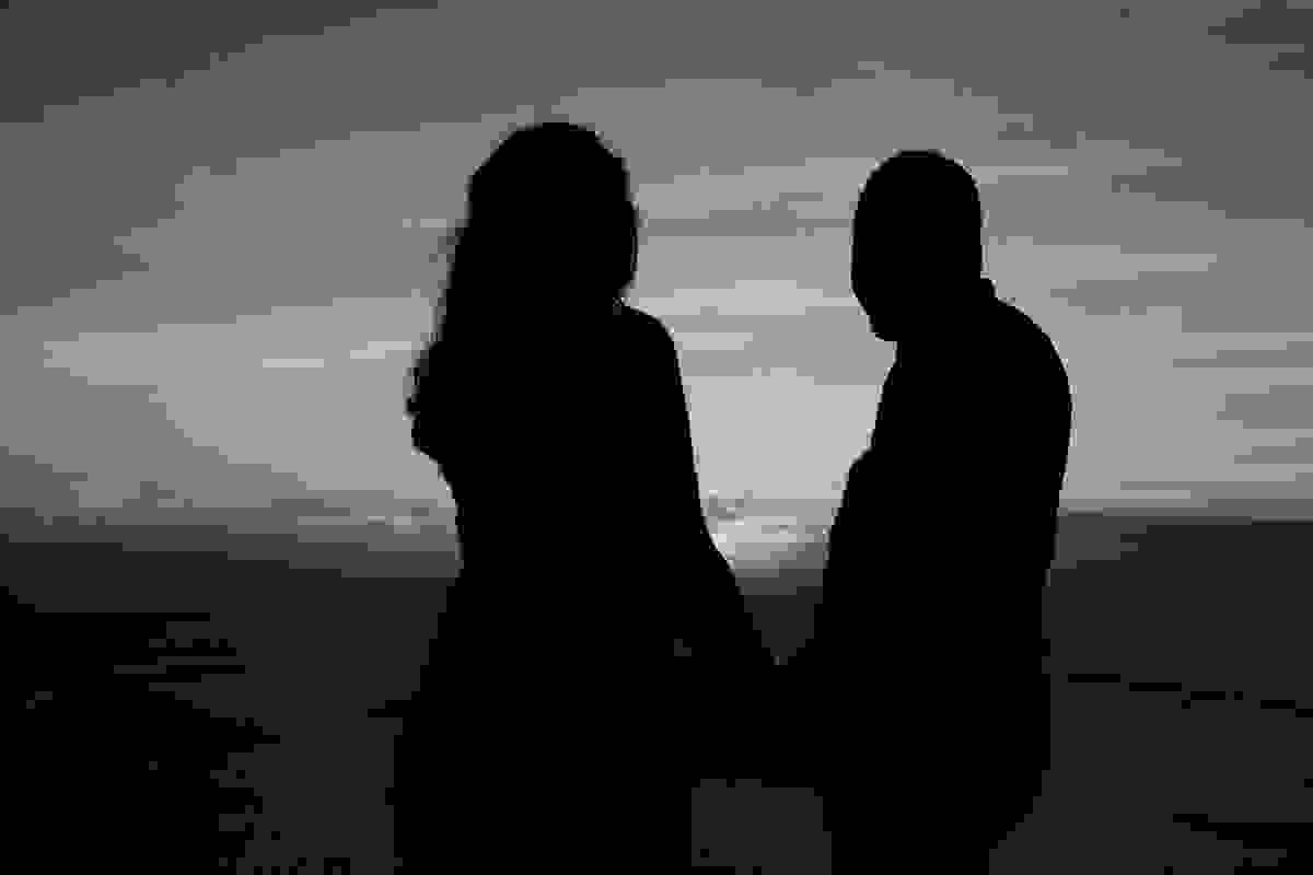 fotografia em silhueta do casal olhando o por do sol