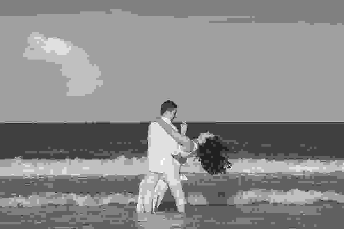 fotografo registra o casal em um momento de descontração na praia do anjos em arraial do cabo onde após o casamento foram passar sua lua de mel