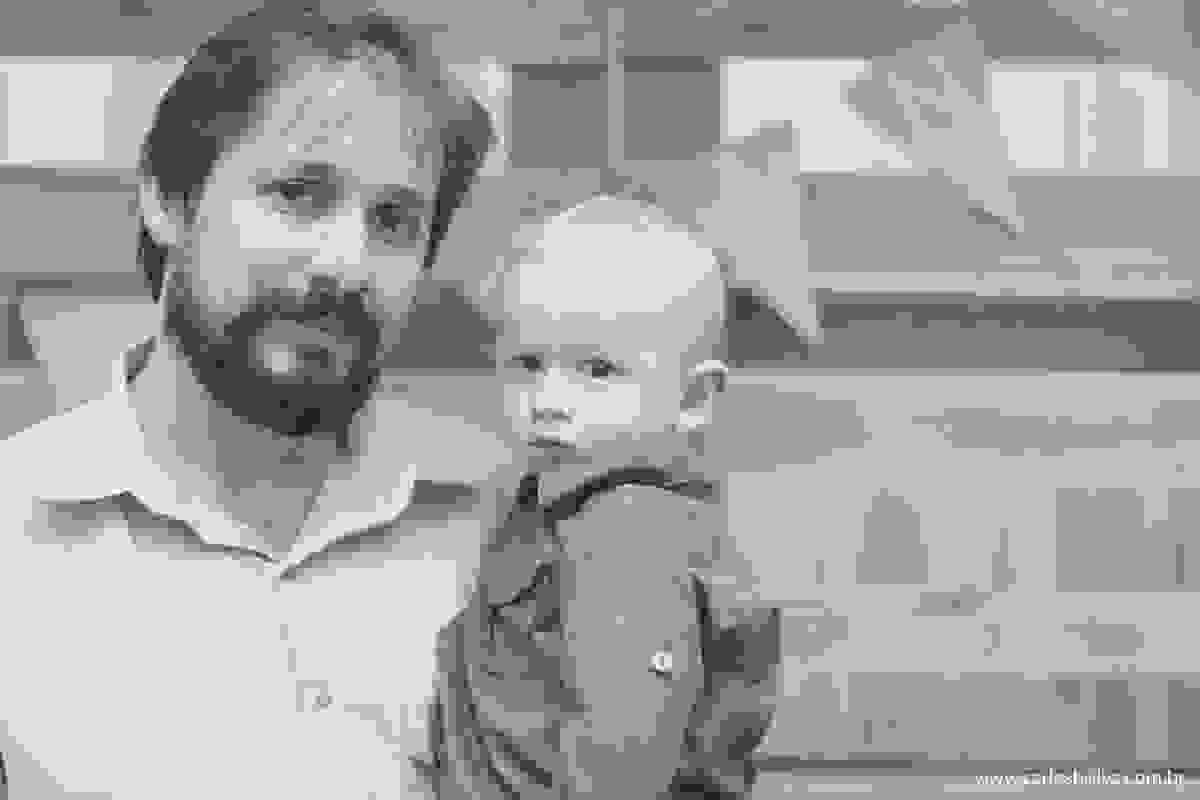 pai e filho tirando foto atras da mesa do bolo