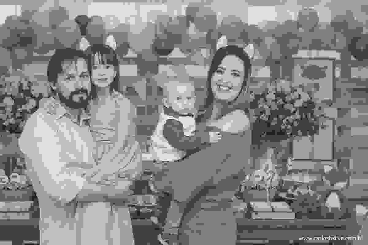 pai, mãe, filha e filhinho frente a mesa do bolo