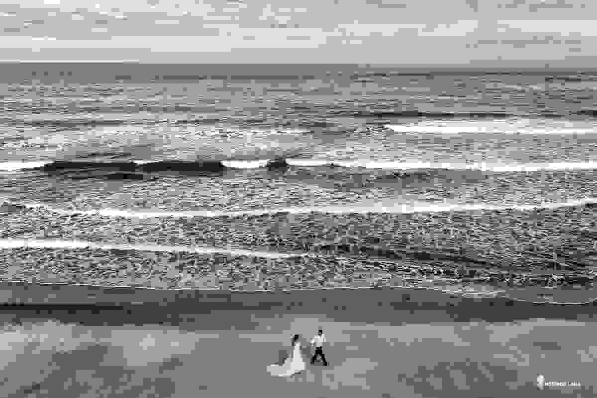 noiva e noivo correndo pela praia felizes para o casamento foto feita por drone
