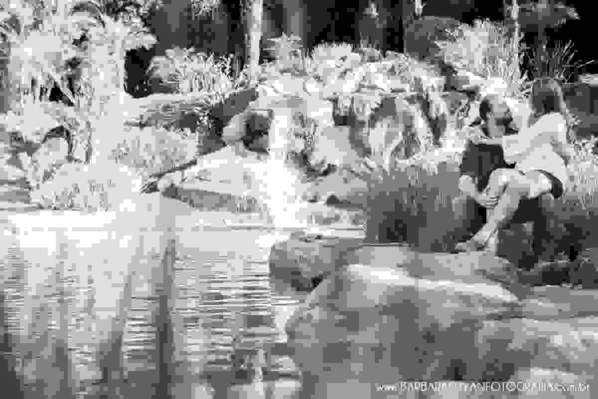 Noivo e noiva sentados ao lado da piscina natural no click da fotógrafa de casamento Minas Gerais MG Bárbara Suyan no Hotel Ville Real em Ouro Preto com muito amor