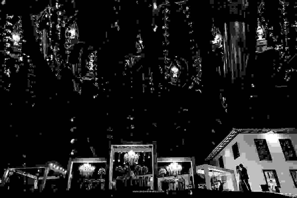 Fotografia artística da decoração do casamento com os noivos em uma linda silhueta.
