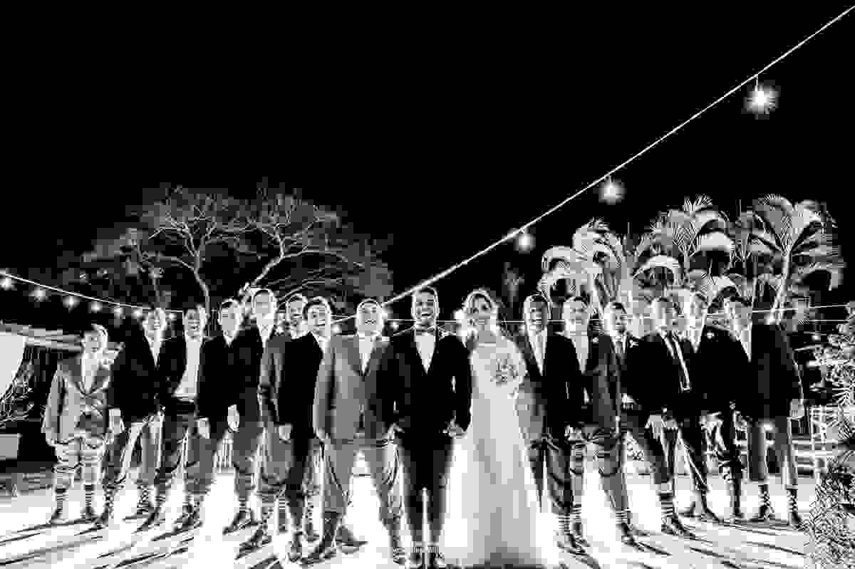 O noivo em uma fotografia descontraída com seus padrinhos e meias coloridas, com listras e de bolinhas
