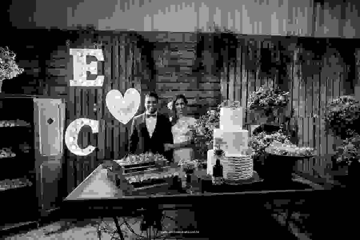 Os noivos na belíssima mesa do bolo, agora casados.