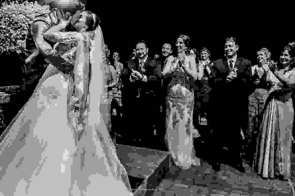 o beijo dos noivos após o sim, aplaudidos por seus familiares