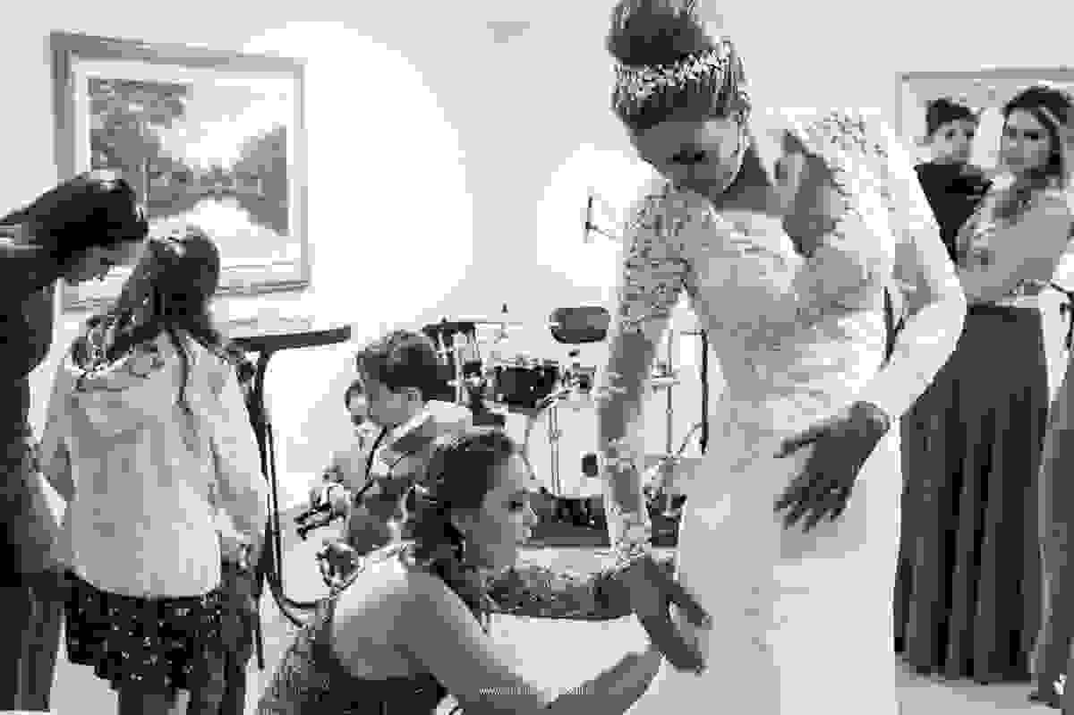 irma da noiva ajustando o vestido de noiva dela na festa de casamento, detalhe vestido desenhado pela própria noiva que é engenheira