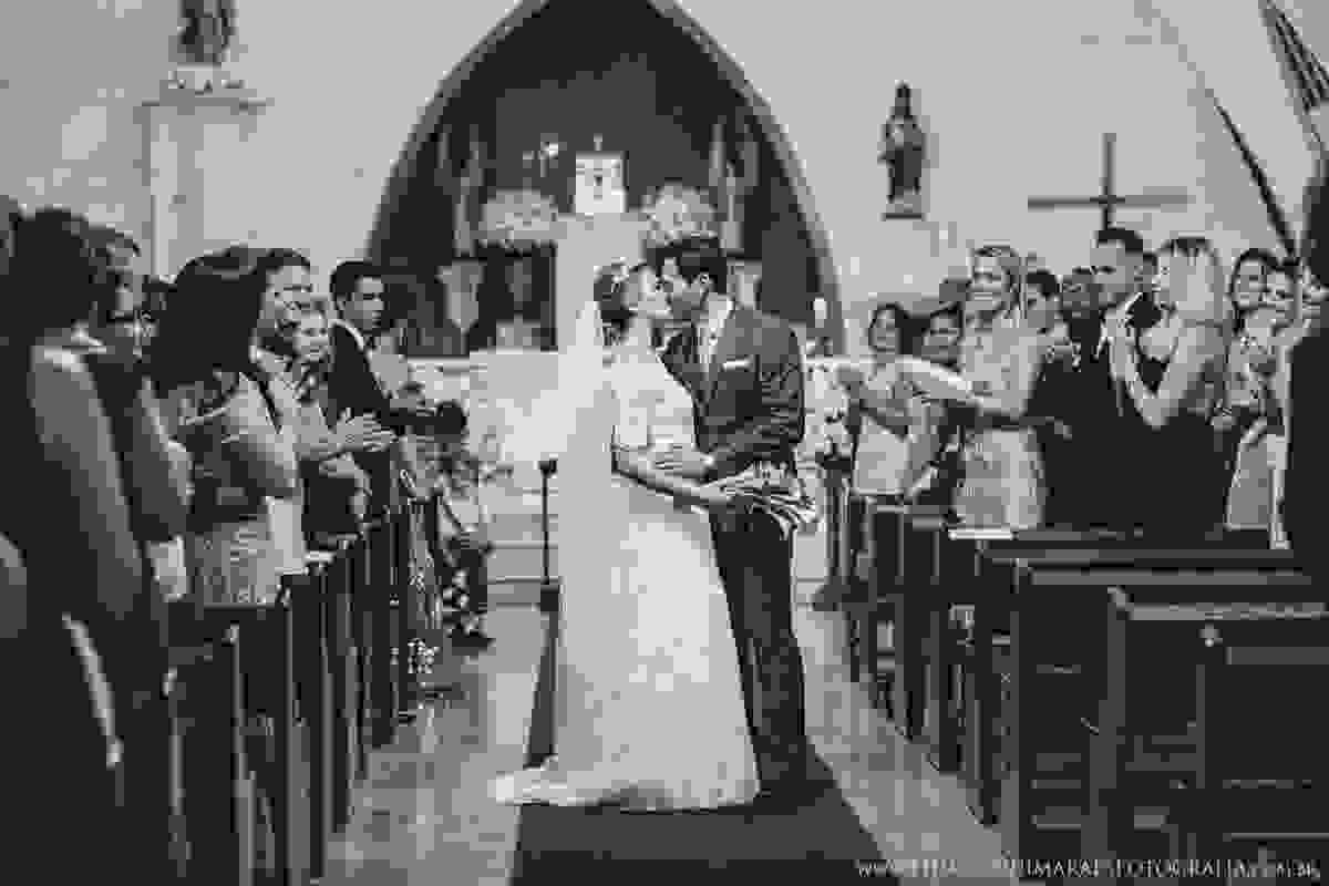 noivo beijando a noiva na saída do altar em santa luzia contagem pelo fotógrafo de casamento BH thiago guimarães numa linda cerimônia sendo aplaudidos