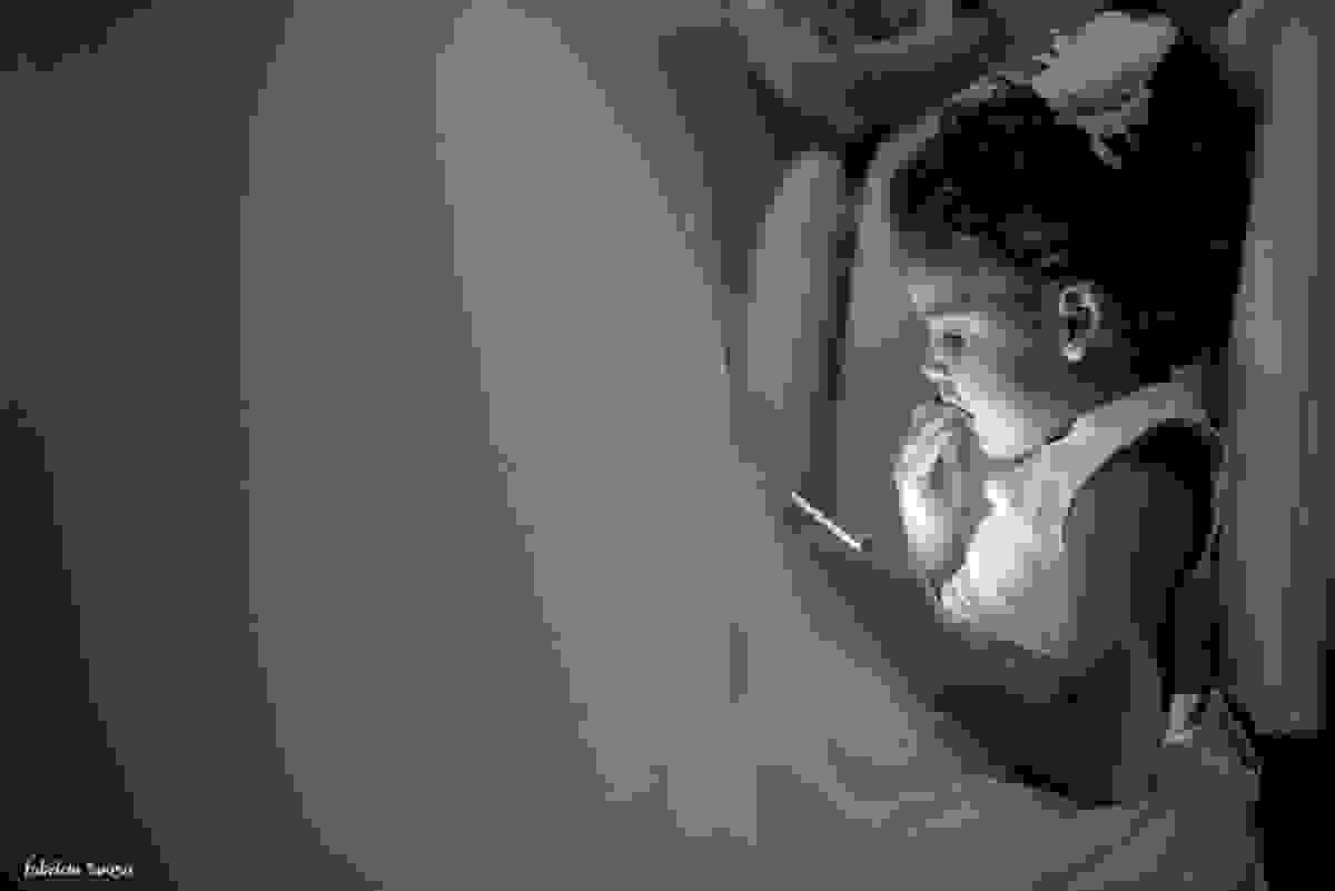 daminha brincando no celular e comendo bolacha durante a festa de casamento