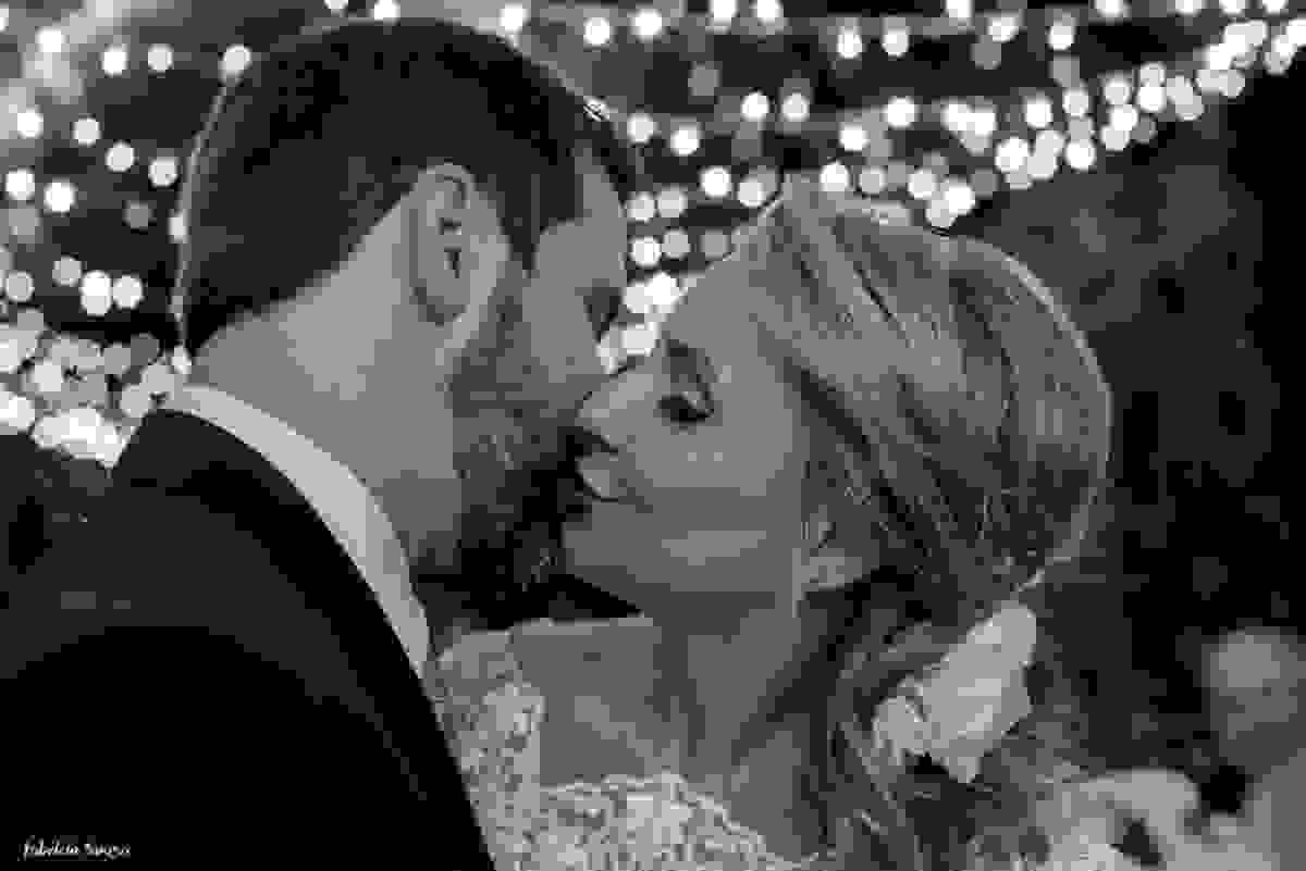 beijo apaixonado do casal com fundo de luzinhas de natal