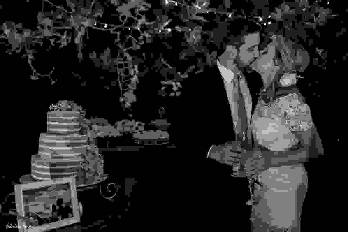 retrato do casal em beijo em frente a mesa de doces Bruna Doces com bolo Ana Petryna e decoração Casa Branca Eventos
