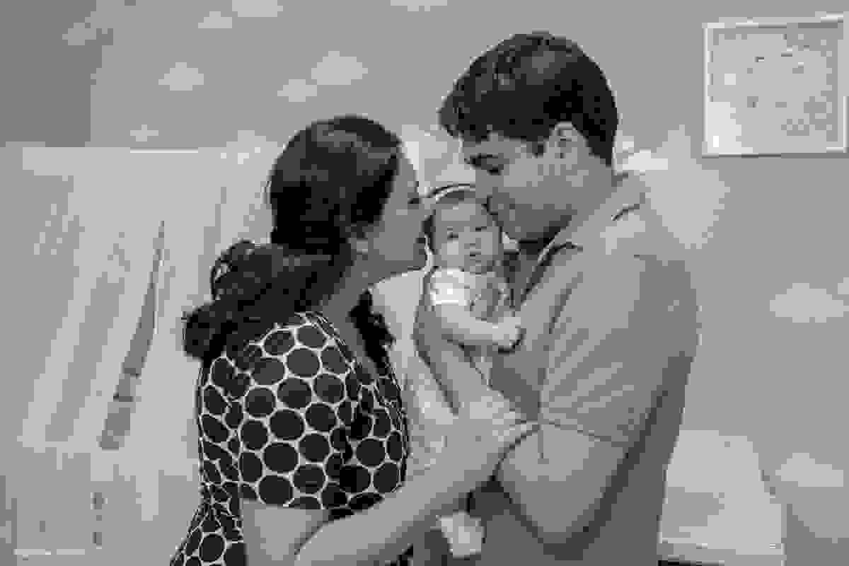 pai e mãe dando um cheiro no bebê em ensaio recem-nascido newborn lifetyle em casa