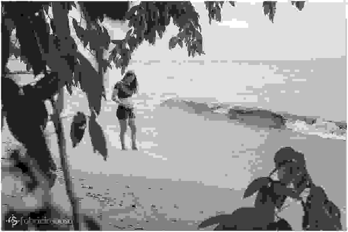 Gestante com os pés na água da praia