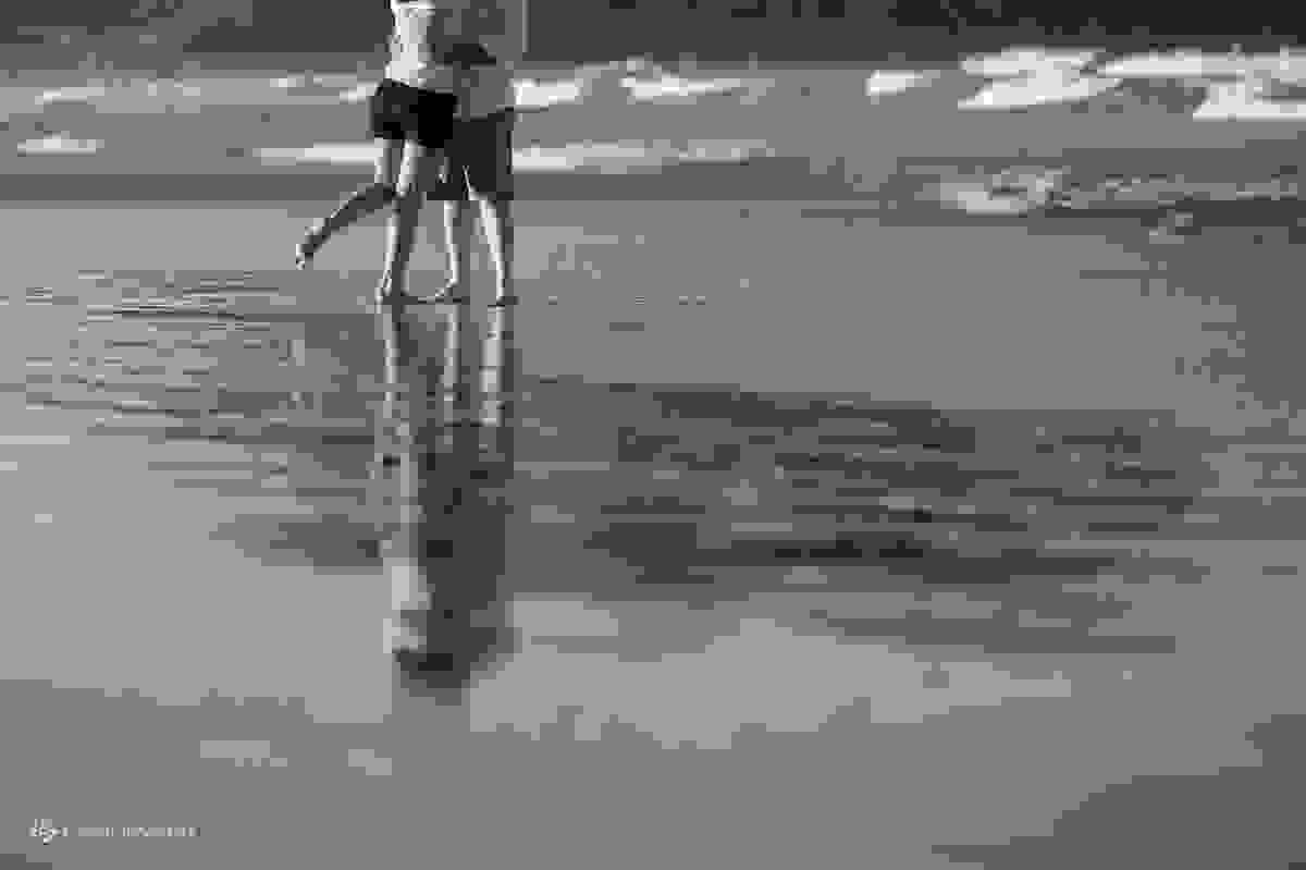 casal com o pé na areia da praia