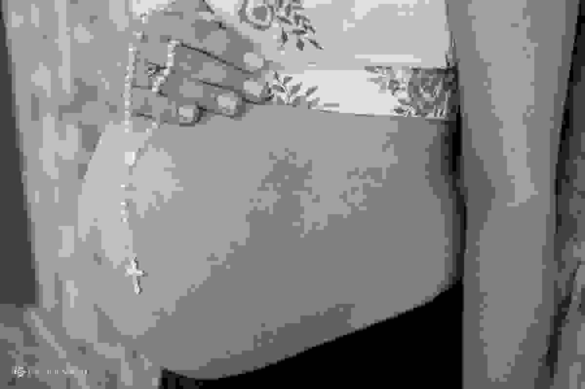 Close da barriga da gestante com terço na mão