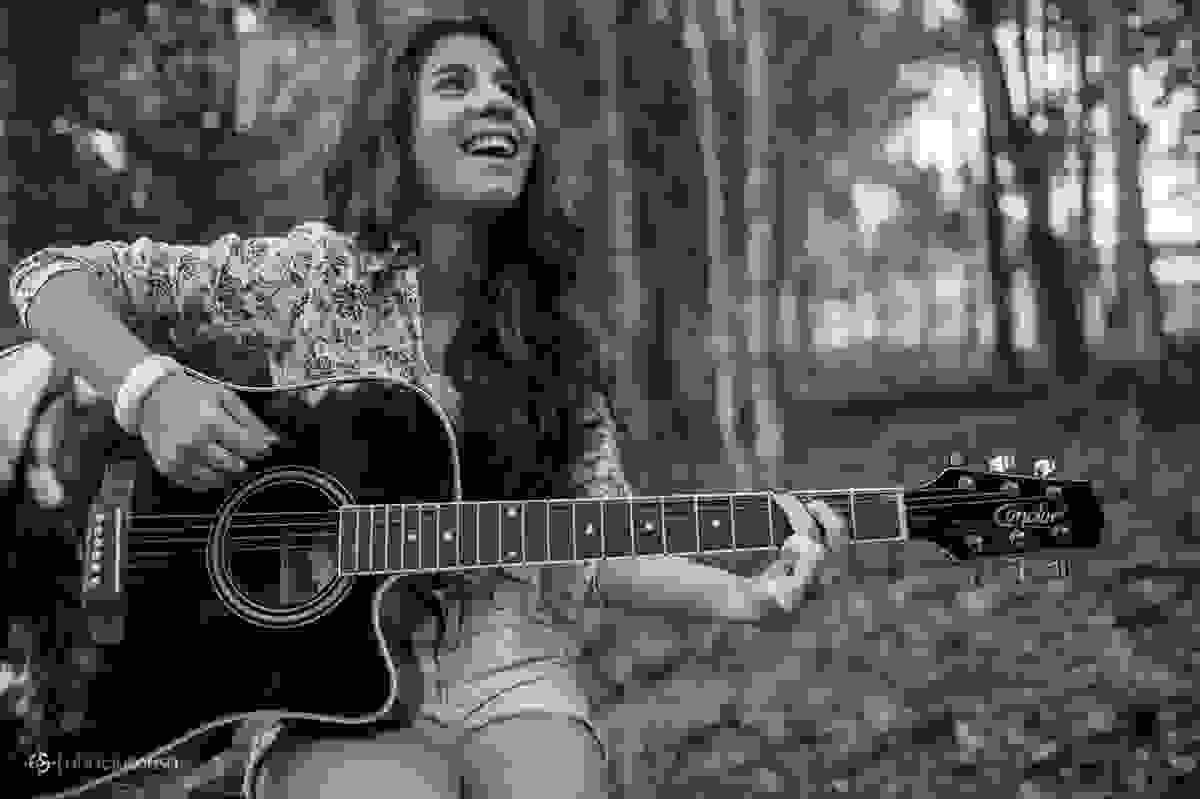 Aniversariante tocando violão em meio à natureza do parque