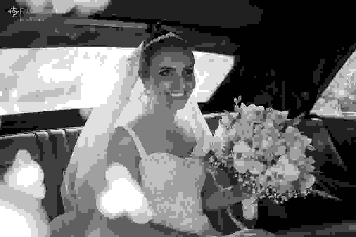 noiva linda e sorridente aguarda para entrar na igreja - dentro do carro