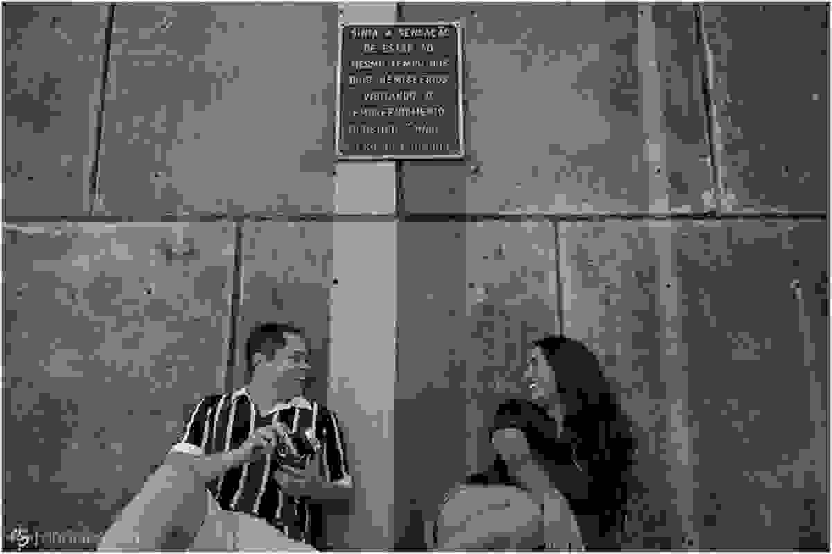 Arilson e Cristiane sentados de cada lado da linha do marco zero