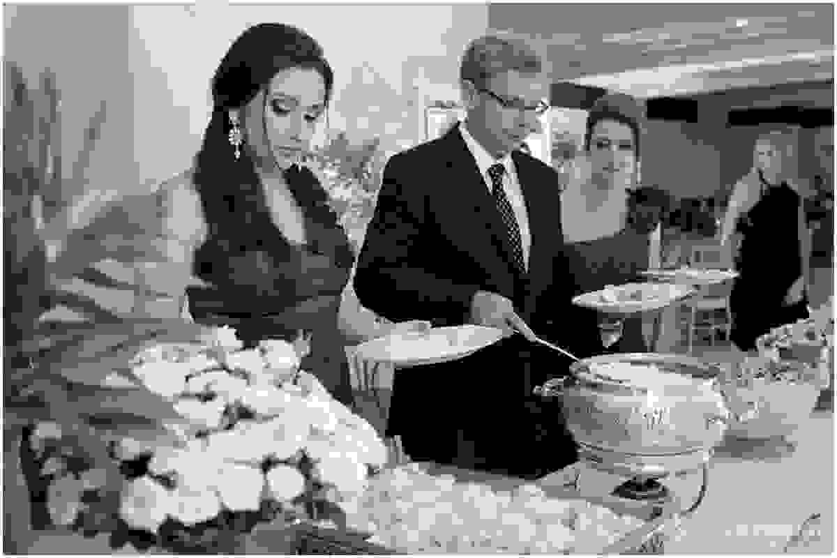 Formanda e os pais se servem para o jantar