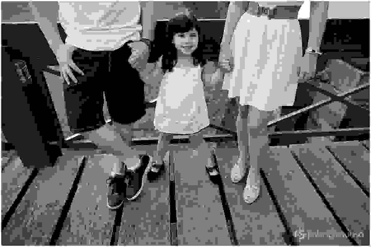 Menina de mãos dadas com os pais
