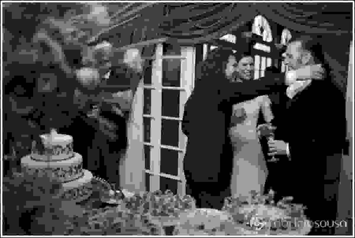 Casal de noivos recebem os cumprimentos em frente a mesa de doces