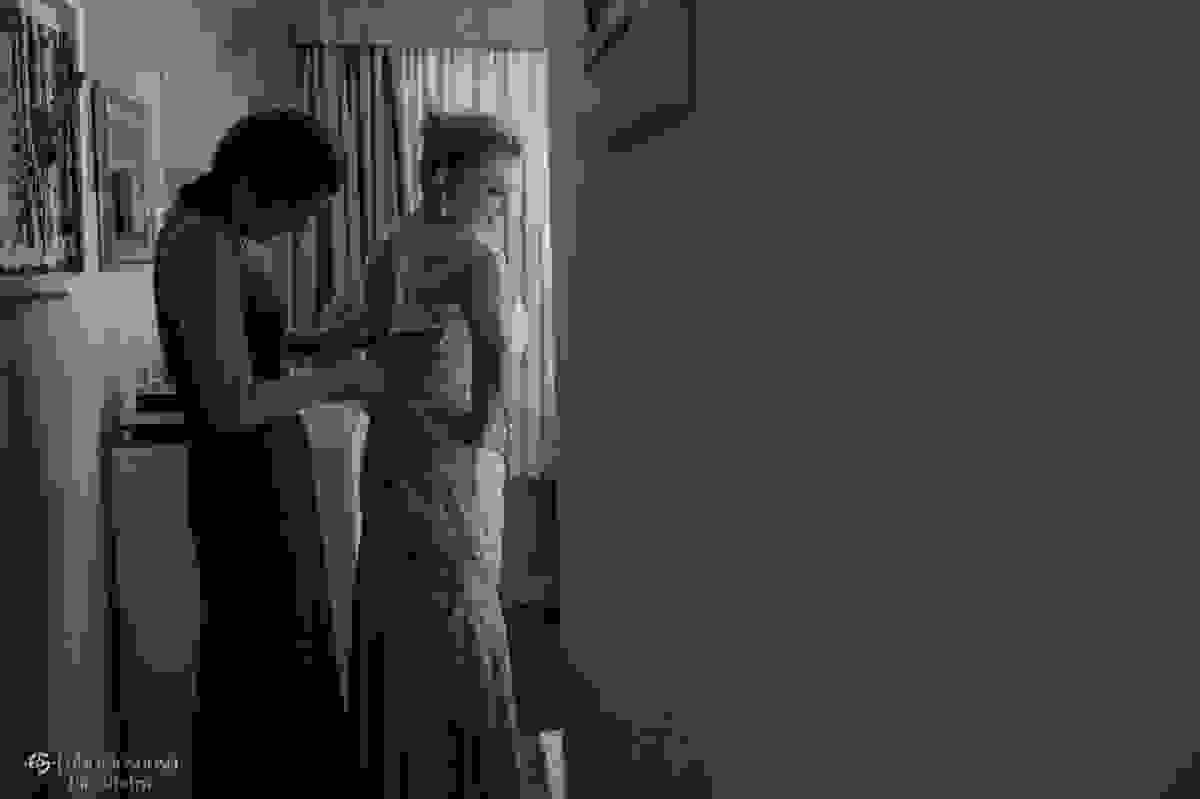 Filha irmã da noiva ajuda a mãe a fechar o vestido