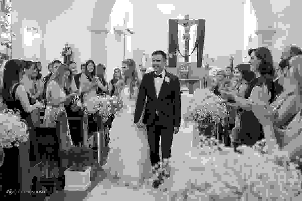 Casal de namorados se dirigem à saída da igreja