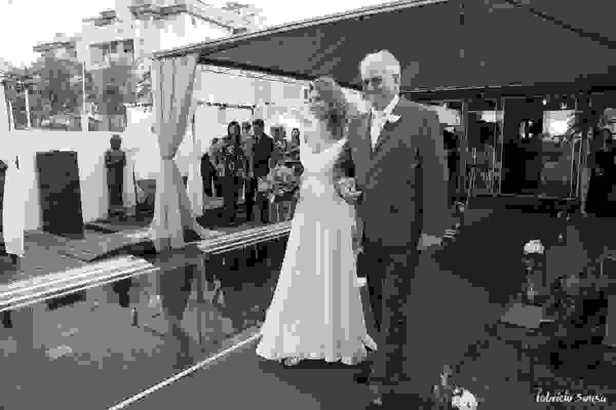 a noiva entrando com o pai na borda da piscina