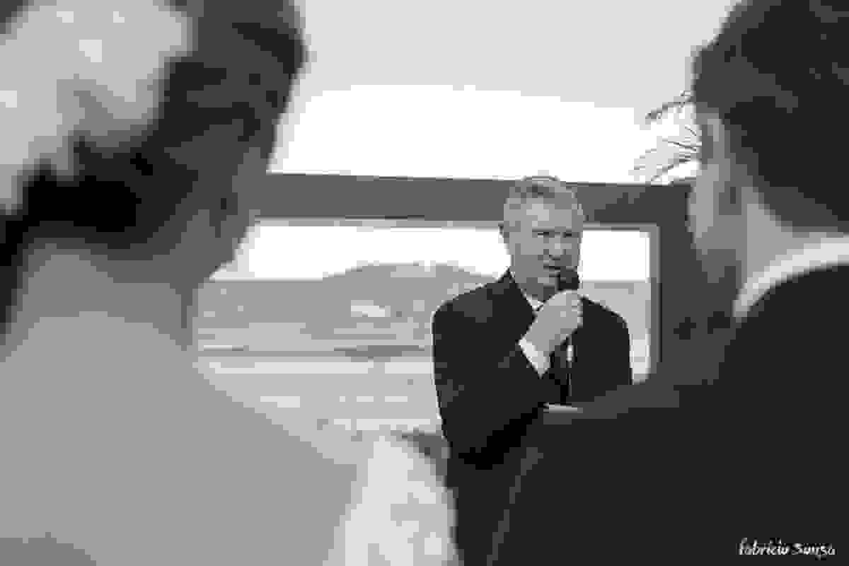 tio da noiva celebrando a cerimonia com o mar de fundo