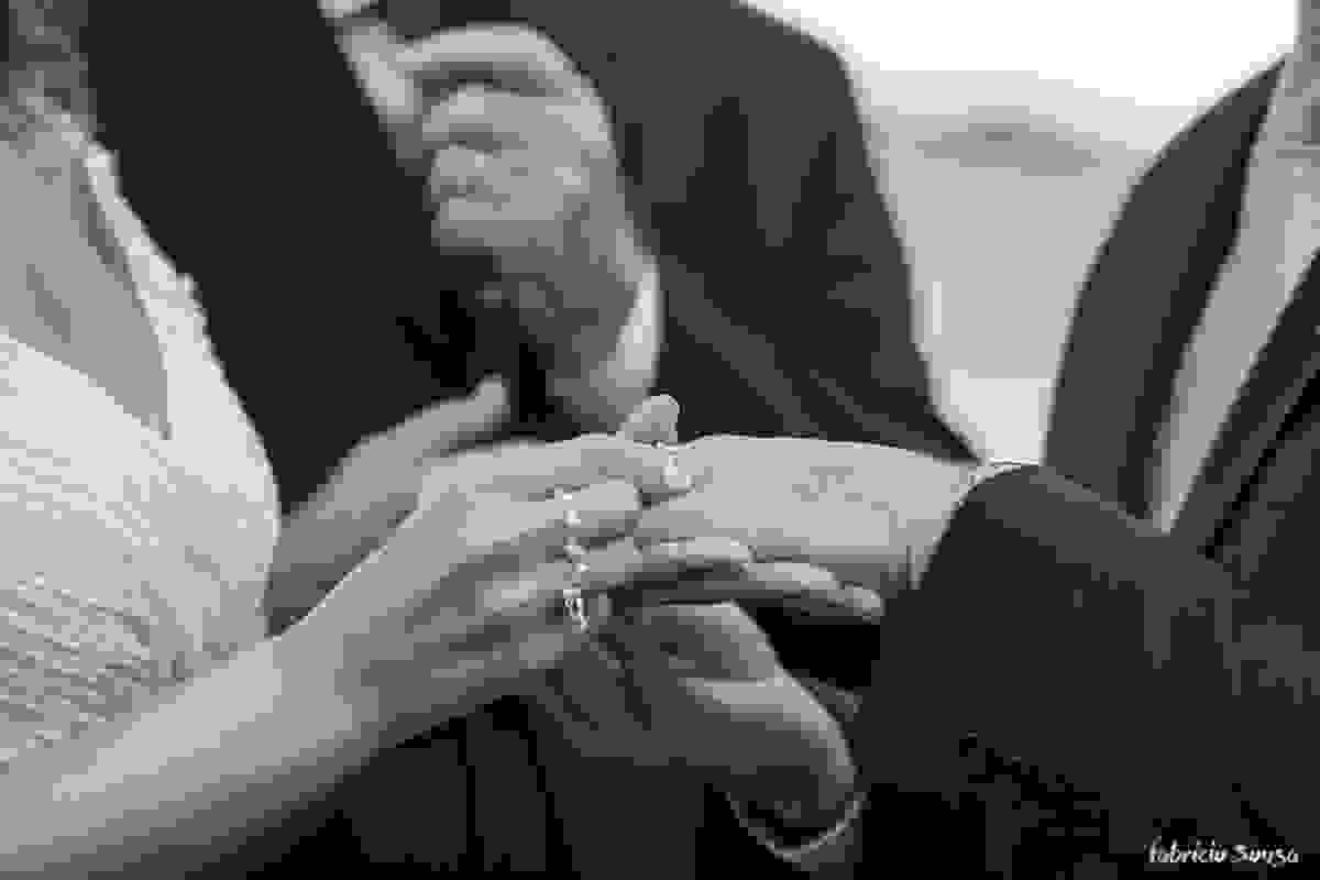 o detalhe das mãos colocando a aliança