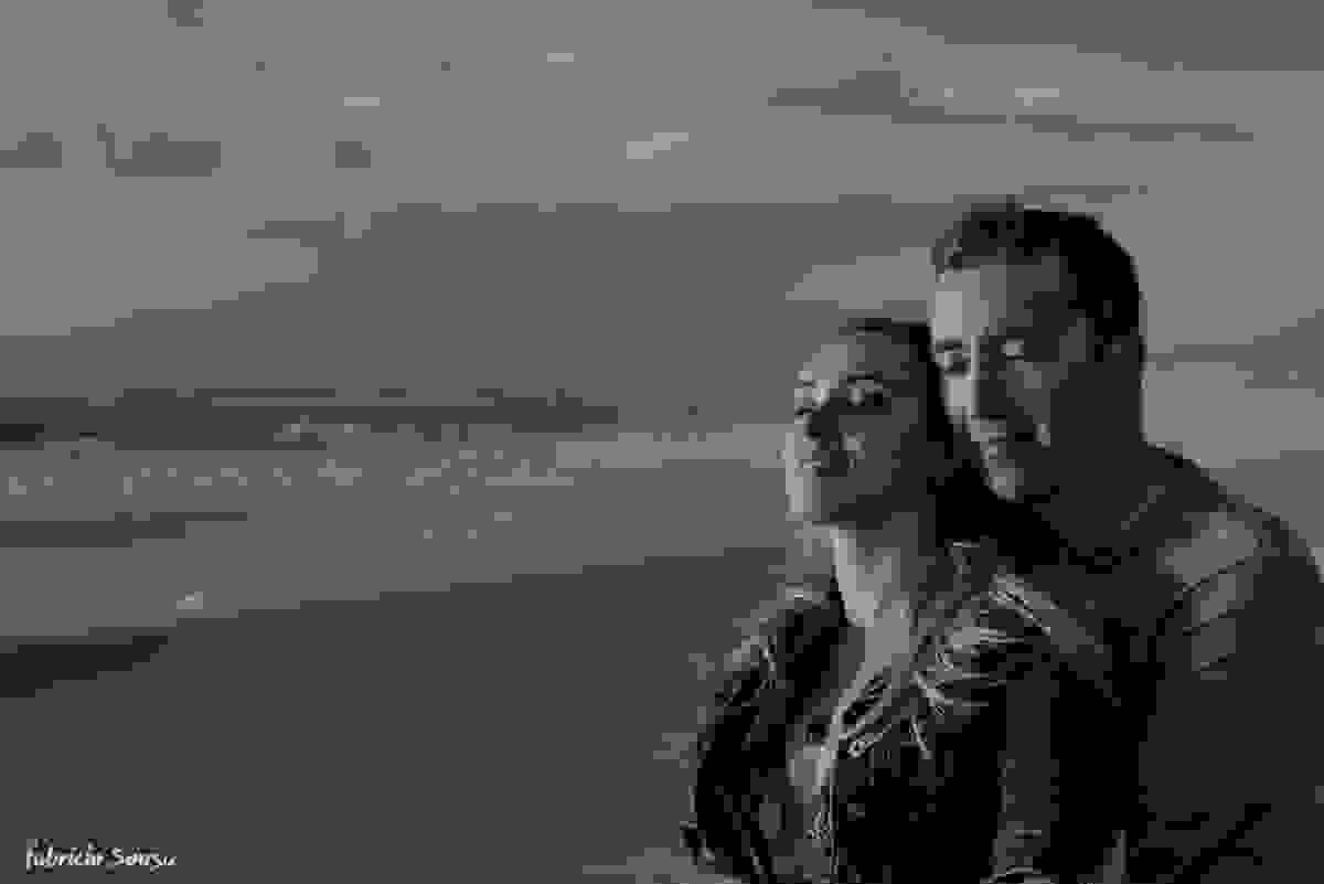 casal de olhos fechados sentindo os primeiros raios de sol do dia na praia do sul da ilha de Santa Catarina