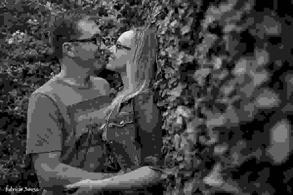 quase beijo do casal apoiado na cerca viva